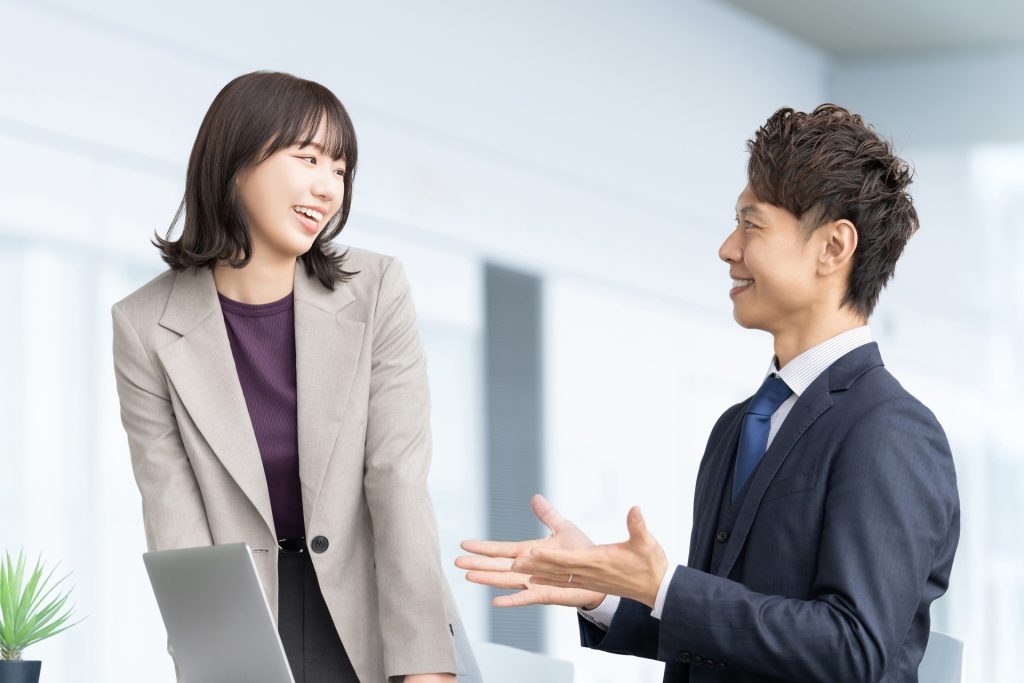 仕事場で楽しく話す男女
