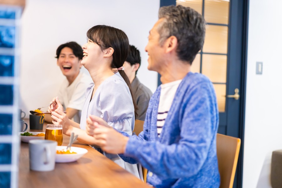 飲食店のカウンターで談笑している50代男女