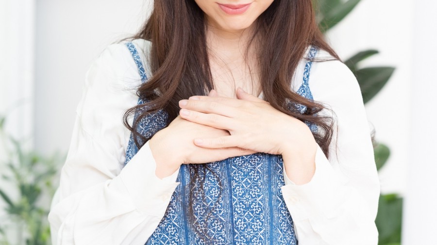 胸に手を当てる女性