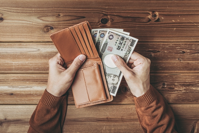 財布からお金を出す男性